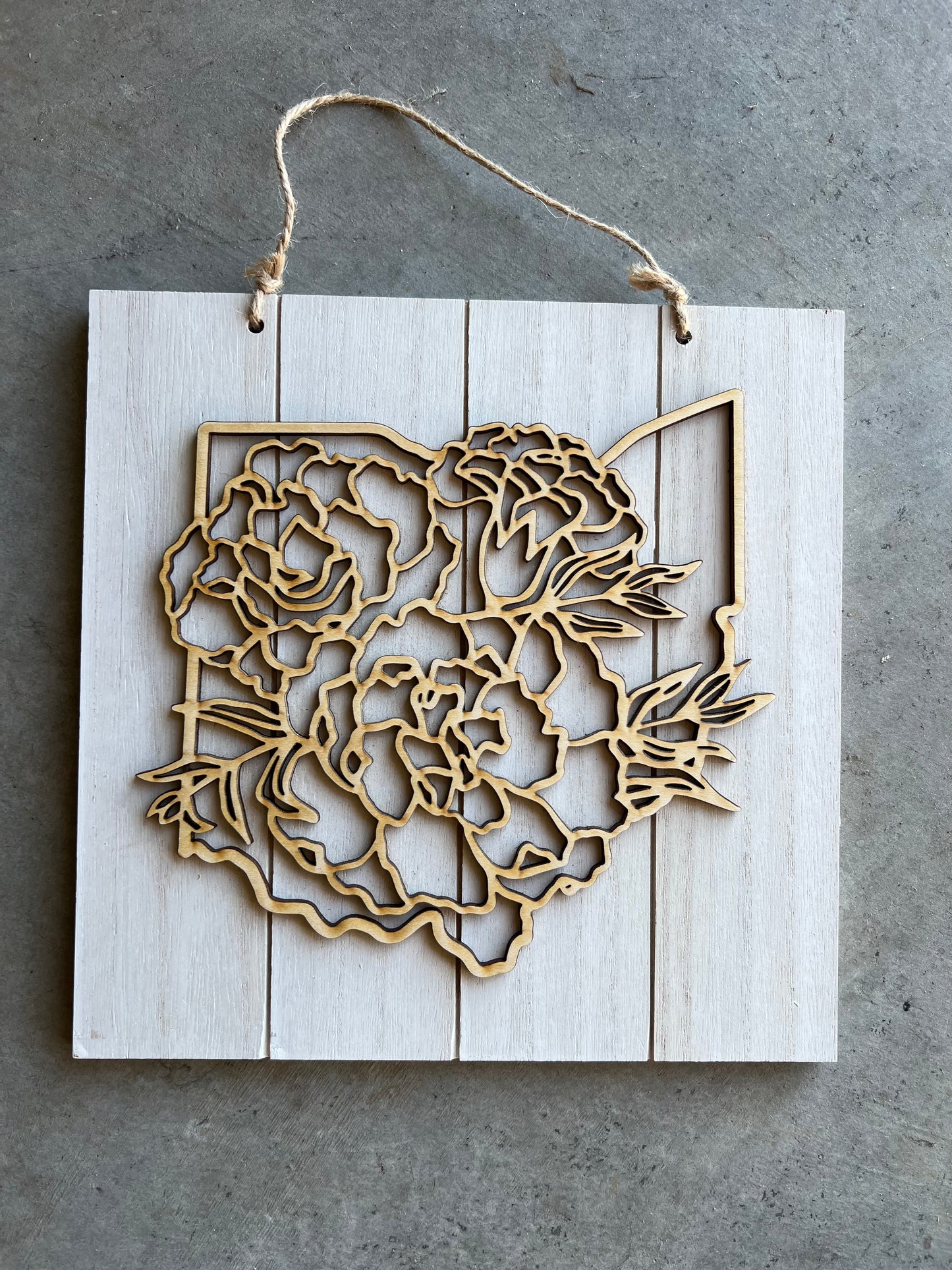 square sign with a top layer of the shape of Ohio and floral