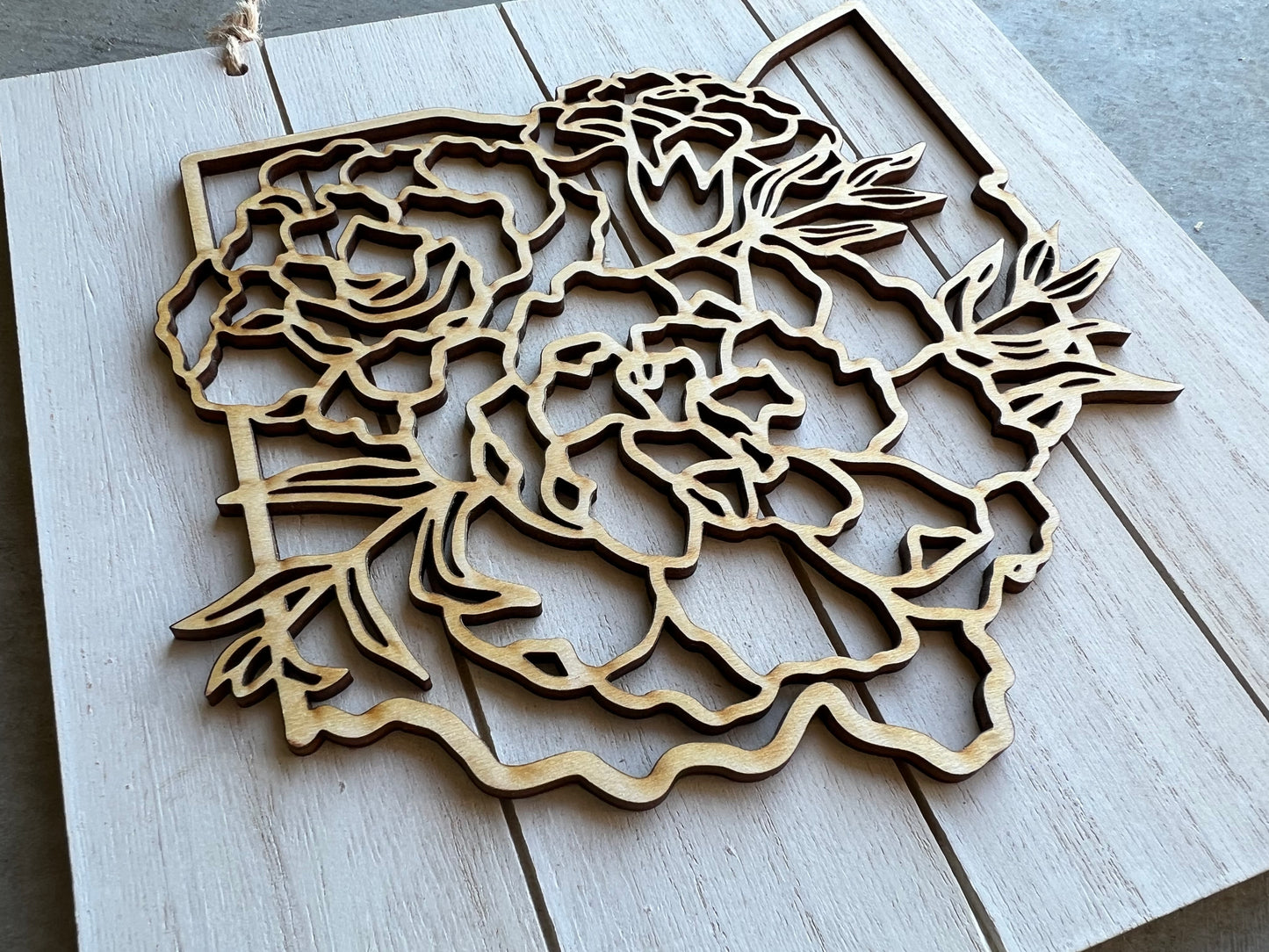 square sign with a top layer of the shape of Ohio and floral