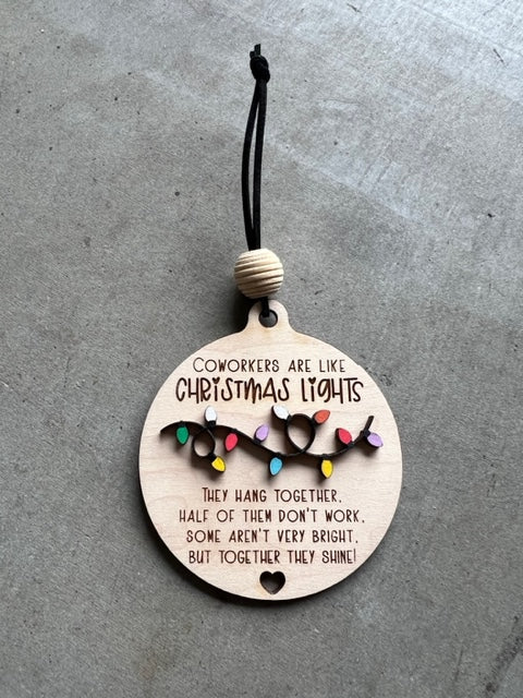 Wooden ornament with Christmas lights and quote "Coworkers are light Christmas lights, they hang together, half of them don't work, some aren't very bright, but together they shine!"
