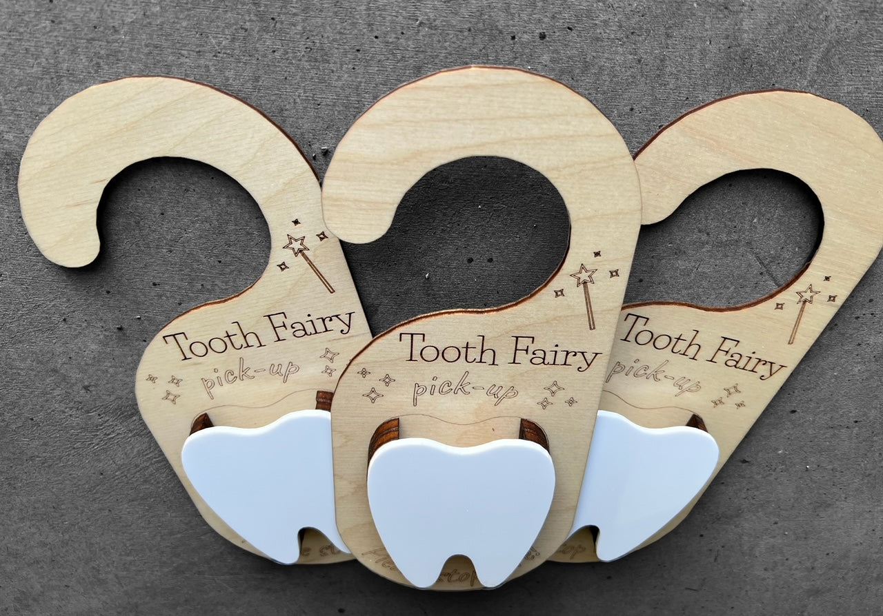 wooden door hanger with the quote "tooth fairy pickup please stop here" White tooth in the center with a pocket to place the actual tooth