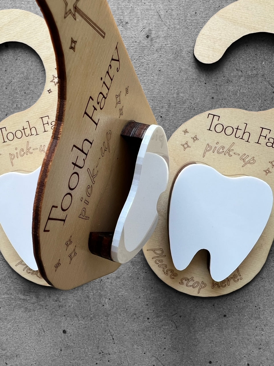 wooden door hanger with the quote "tooth fairy pickup please stop here" White tooth in the center with a pocket to place the actual tooth