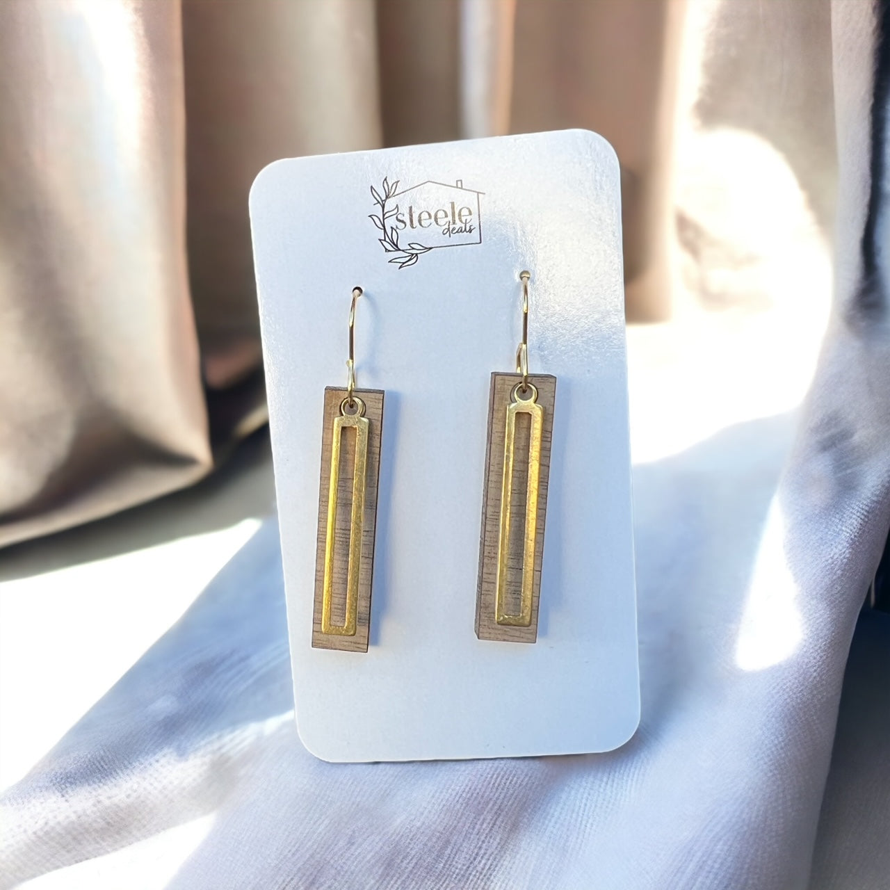 dangle earrings in the shape of a rectangle, made with a base layer of wood and top layer of metal
