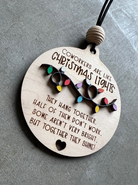 Wooden ornament with Christmas lights and quote "Coworkers are light Christmas lights, they hang together, half of them don't work, some aren't very bright, but together they shine!"