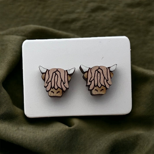wood stud earrings in the shape of a highland cow