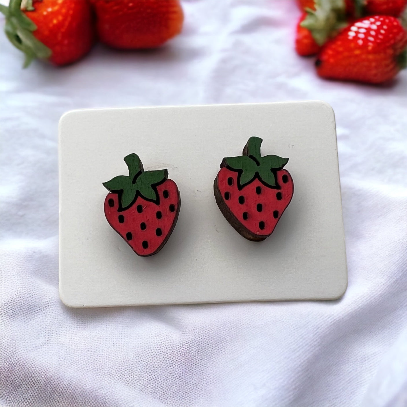 hand painted wooden stud earrings in the shape of a whole strawberry