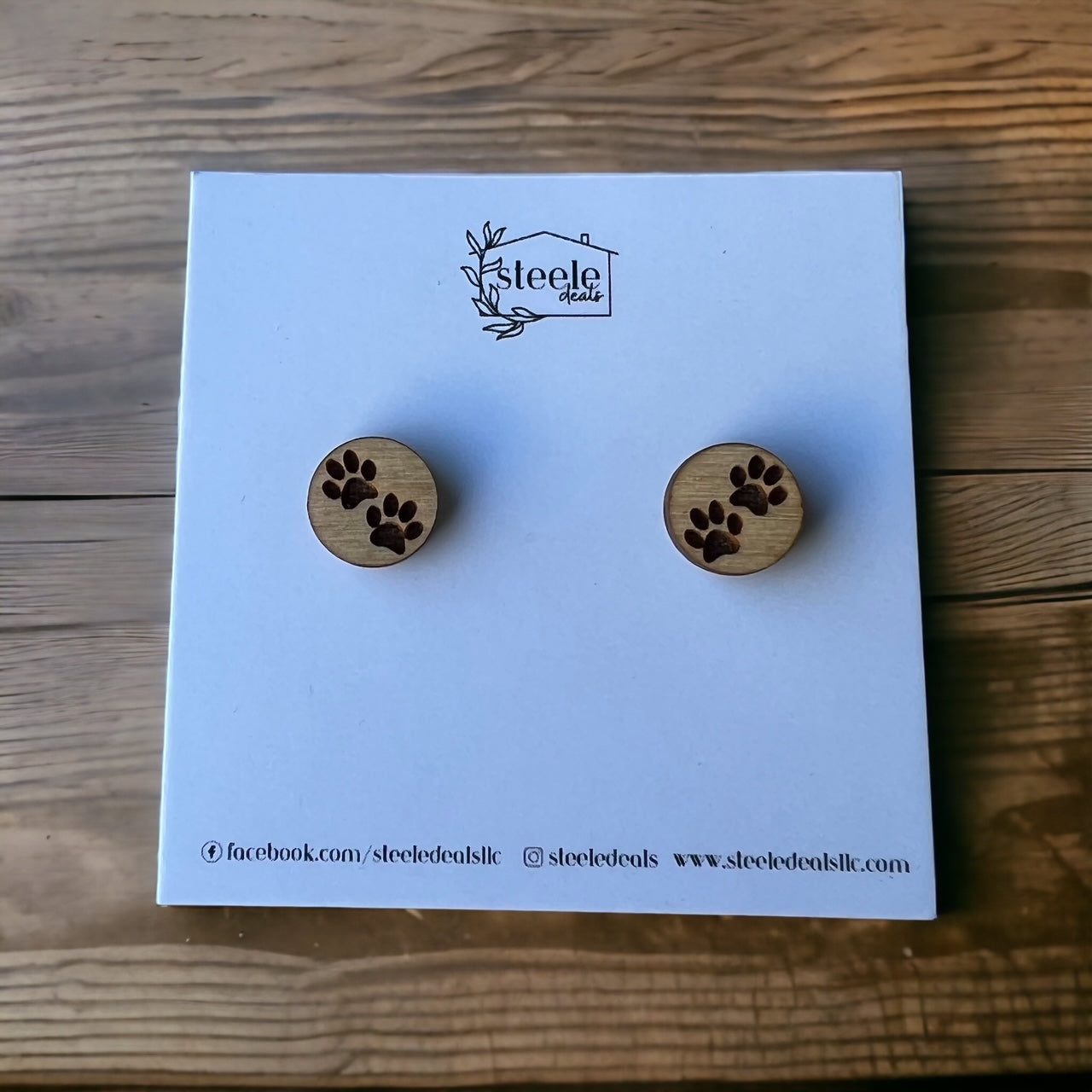 circle shaped wood stud earrings with two paw prints on each earring