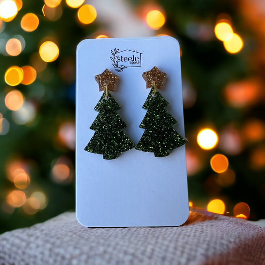 acrylic dangle earrings in the shape of a gold star on top a green Christmas tree