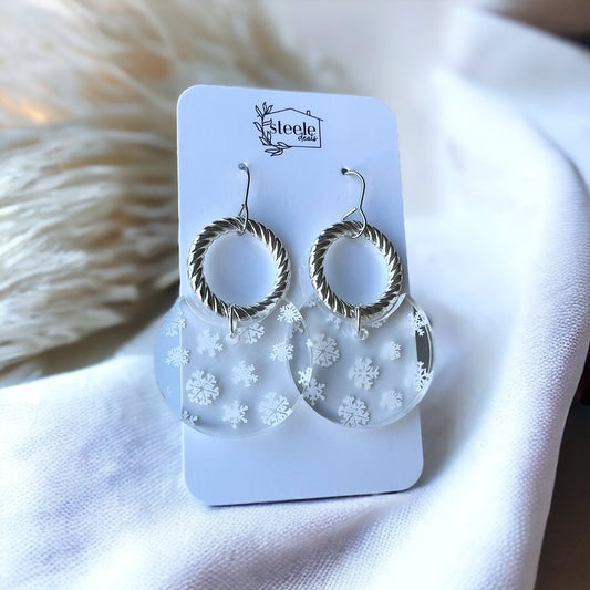 dangle earrings with a rope circle as the top layer and semi circle with white snowflake pattern right below it
