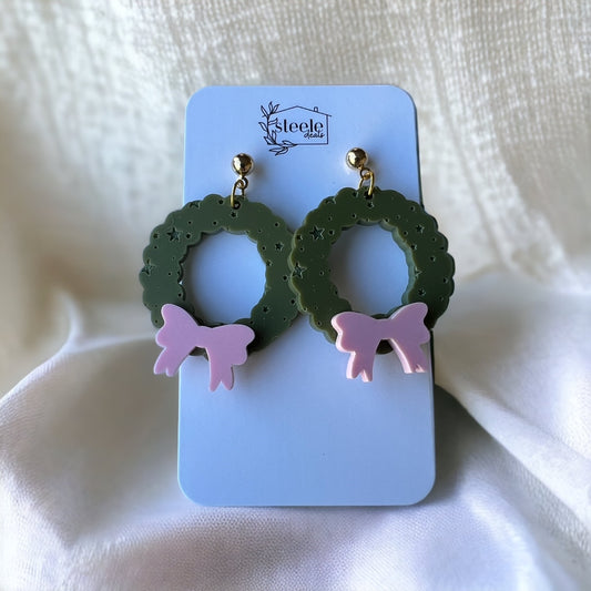 ball post dangle earrings in the shape of a green wreath with light pink bow on the bottom